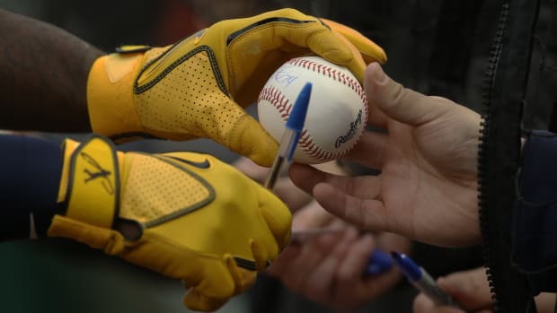 Apr 27, 2022; Pittsburgh, Pennsylvania, USA; Milwaukee Brewers designated hitter Andrew McCutchen (24) returns an autographed baseball to a fan before the game against the Pittsburgh Pirates at PNC Park. Mandatory Credit: Charles LeClaire-USA TODAY Sports