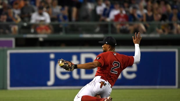 Jul 22, 2022; Boston, Massachusetts, USA; Boston Red Sox shortstop Xander Bogaerts (2) slides after making a catch for an out during the sixth inning against the Toronto Blue Jays at Fenway Park. Mandatory Credit: Bob DeChiara-USA TODAY Sports