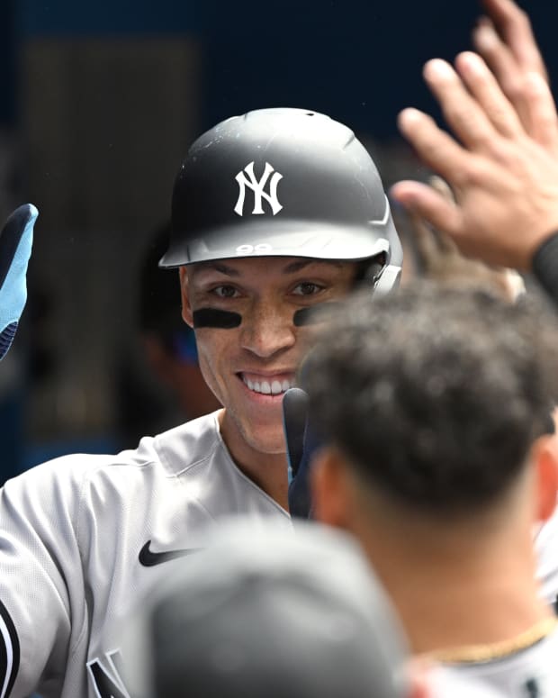 Jun 19, 2022; Toronto, Ontario, CAN; New York Yankees center fielder Aaron Judge (99) is greeted by team mates in the dugout after scoring against the Toronto Blue Jays in the fifth inning at Rogers Centre. Mandatory Credit: Dan Hamilton-USA TODAY Sports